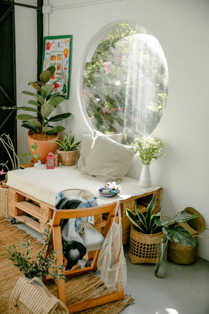 pexels-photo-6850585-6850585 A peaceful indoor setting with plants, wicker baskets, and soft cushions bathed in sunlight.